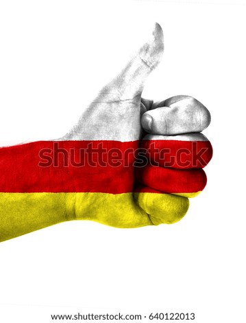 Hand making thumbs up sign.North Ossetia painted with flag as symbol of thumbs like,up,okay. Isolated on white background.