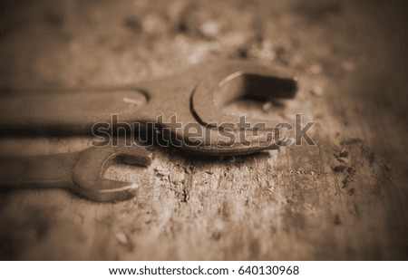 Old rusty wrenches on wooden background. Very small DOF