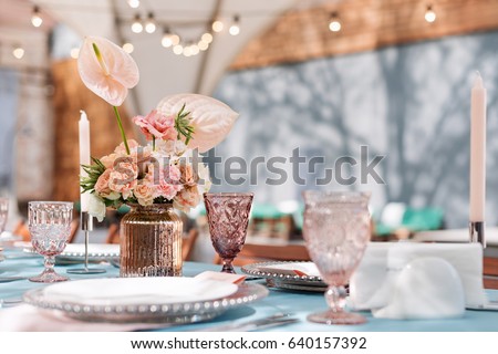 Flower table decorations for holidays and wedding dinner. Table set for holiday, event, party or wedding reception in outdoor restaurant. Royalty-Free Stock Photo #640157392