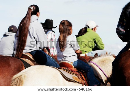 Mother and daughter watching the action at a rodeo.