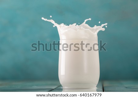 glass of milk on a wooden table on a blue background healthy food