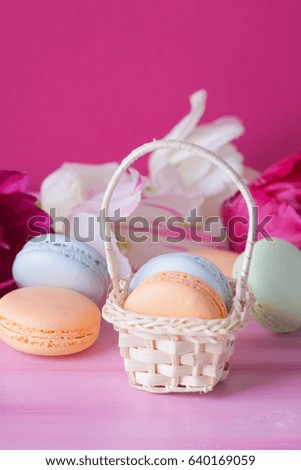 macaroons and tulips on pink wooden background .Present on Mothers day, Valentines Day or Womens day.