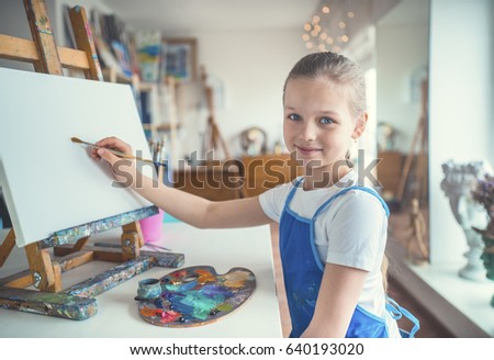 Smiling girl in painting studio