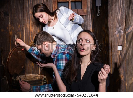 Company of young people trying to solve a conundrum to get out of the trap, escape the room game concept Royalty-Free Stock Photo #640251844