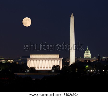 Full Harvest moon rising above the Lincoln Memorial with Washington Monument and Capitol building aligned