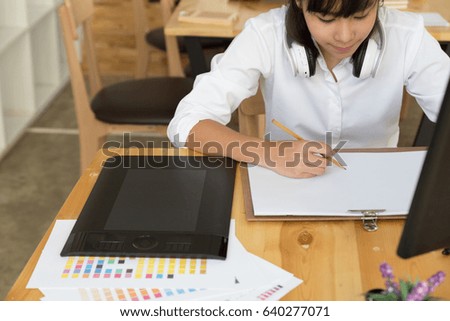 freelance artist graphic designer drawing on white paper with digital tablet and color swatch catalog samples on wood desk  - Creativity Editor Ideas Concept