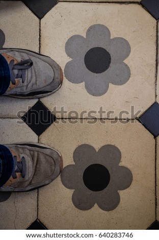Standing, with my feet on a beautiful tiles with decorations of flowers.