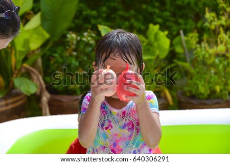 child playing  water balloons.