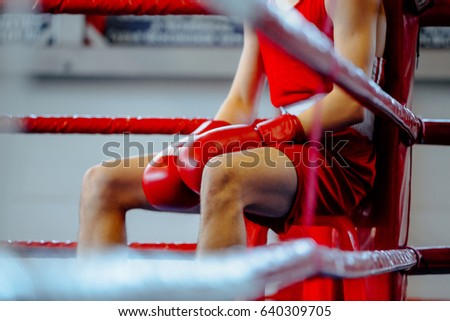young boxer man in corner boxing ring in break between rounds