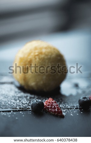 Grilled ice-cream in coconut with sauce on black stone plate. Asian food background. Eating concept. Restaurant place with wooden table. Copy space for text, design.
