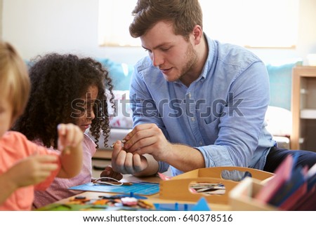 Teacher And Pupils Working At Tables In Montessori School Royalty-Free Stock Photo #640378516