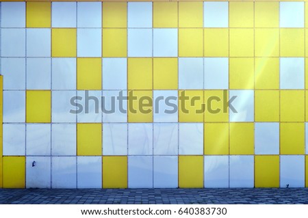 The texture of the metal wall, framed in the form of colored squares of two colors. Modern wall design for the exterior of residential and office buildings