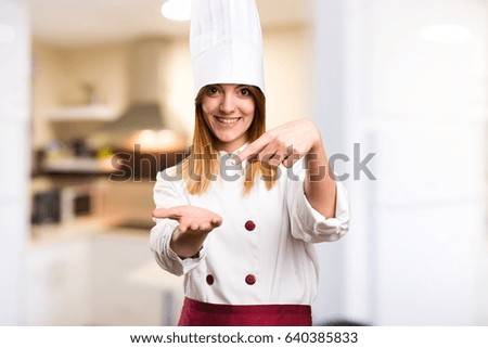 Beautiful chef woman holding something in the kitchen