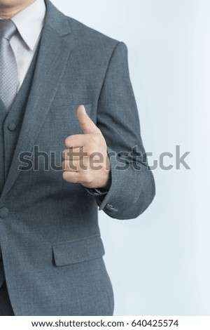 The business man holds his thumb to show his satisfaction.