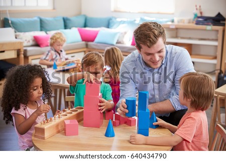 Teacher And Pupils Working At Tables In Montessori School Royalty-Free Stock Photo #640434790
