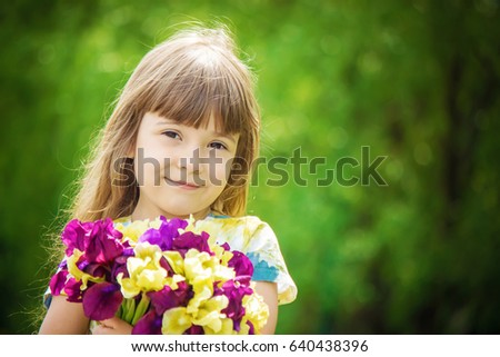 Girl with a bouquet of irises. Selective focus. 