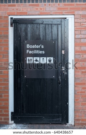 A black, wooden door, with a sign saying 'Boaters Facilities', and four icons showing the facilities on offer