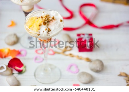 Ice cream dessert on table with hearts, ribbons and cloves