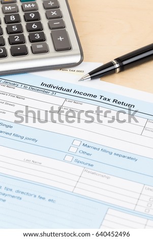 Tax form with pen and calculator; document are mock-up