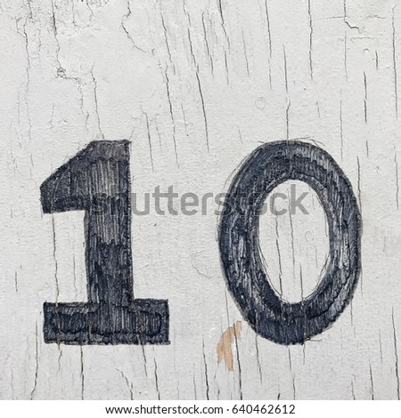 Number 10 ten house number address sign painted one white wood fence textured background