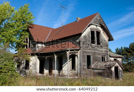 Photograph of an old abandoned and spooky home in the central part of Wisconsin with a beautiful blue sky in the background, and surrounded by the colors of late summer and early autumn.