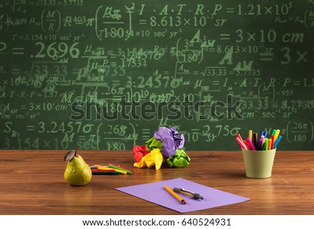 A stuffed school desk with green blackboard in the background full of numbers, calculation