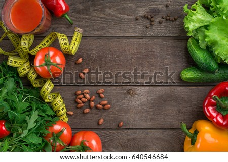 Glass of tomato juice with vegetables and measuring tape on table close-up