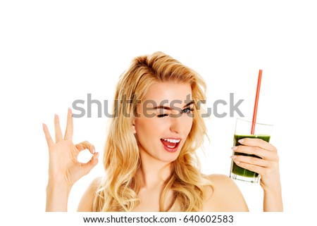 Young woman drinking green cocktail