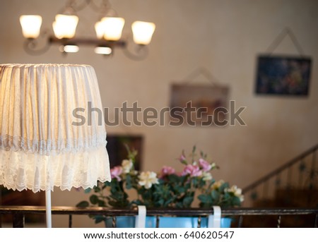 A vintage included floor lamp on the wall background with pictures