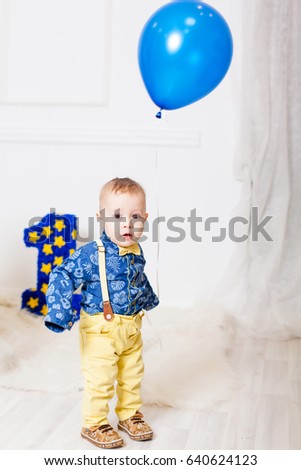 Photo of a little boy with a balloon . Birthday is one year. Volumetric blue digit