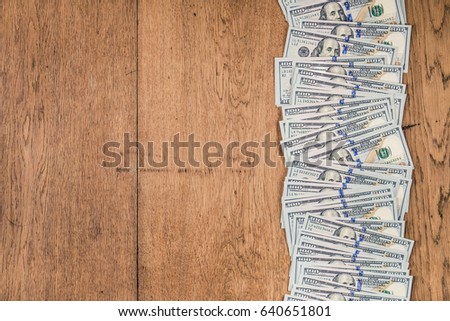 USA dollars cash money on old retro textured wooden table. Business, money or financial deals conceptual background. Vintage style filtered photo