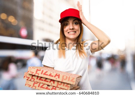 Pizza delivery woman having doubts on unfocused background