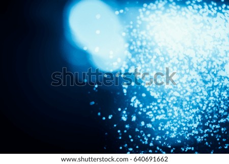 Abstract shimmering bokeh or glitter lights on blue background. Circles and defocused particles. Template for design