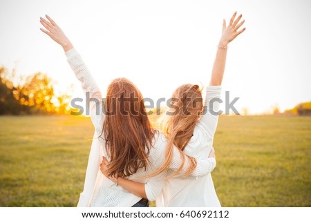 Young women are having fun on the green field in the evening. Royalty-Free Stock Photo #640692112