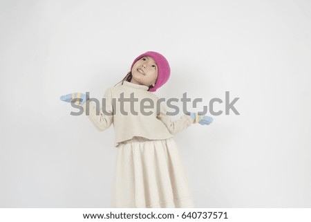 Little asian girl wear a warm hat and gloves / it's a snowy day