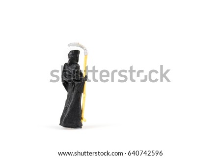 Miniature grim reaper on white background with space for text