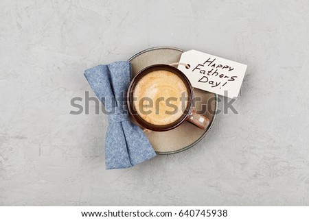 Morning cup of coffee and bowtie on stone desk top view in flat lay style for breakfast on Happy Fathers Day.