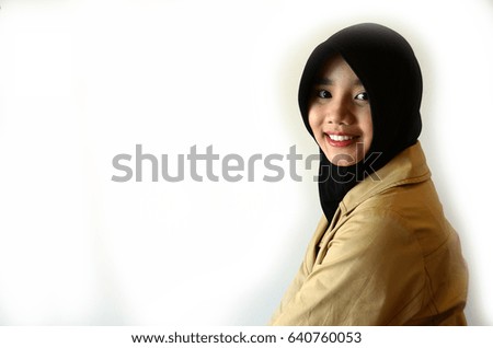 Beautiful Muslim girl smiling at the camera while taking her picture. White background
