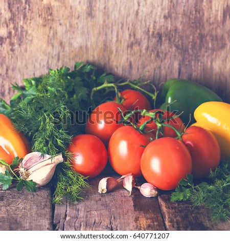 Fresh vegetables- tomatoes, bell pepper, garlic and  herbs on old wooden background. Rustic style. Ingredients for the salad, spaghetti.