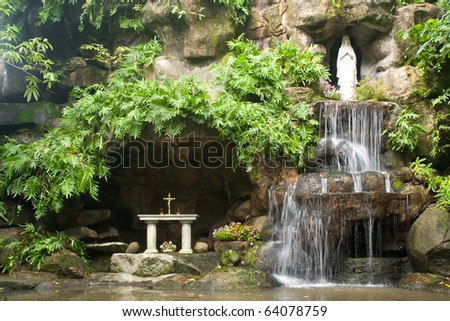 Waterfalls in the park. A statue of the goddess. Of Christianity.