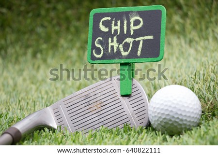 Golf Chip out word on black board sign with iron and golf ball on green grass with golf club