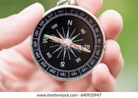 A man holding a compass in hand, macro photo. Travel concept