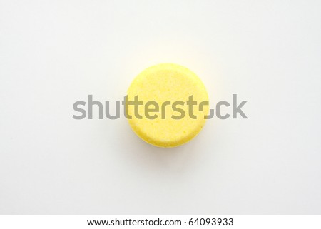 Yellow tablet for patient on white paper.