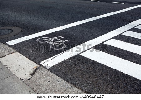 Bike lane along pedestrian road crossing, close up view at white painted marks
