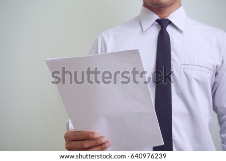 young asian businessman holding his report papers.