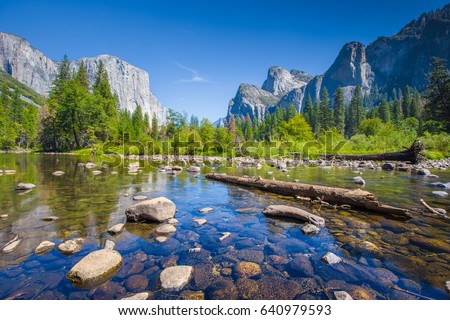 Classic view of scenic Yosemite Valley with famous El Capitan rock climbing summit and idyllic Merced river on a sunny day with blue sky and clouds in summer, Yosemite National Park, California, USA Royalty-Free Stock Photo #640979593