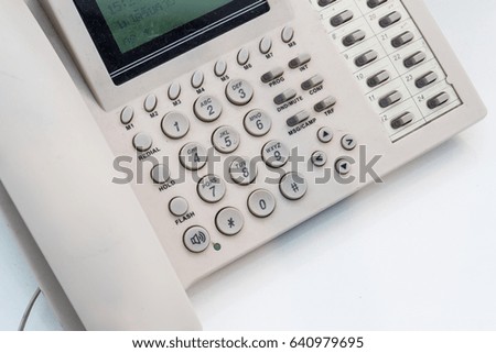 white digital telephone on table in office