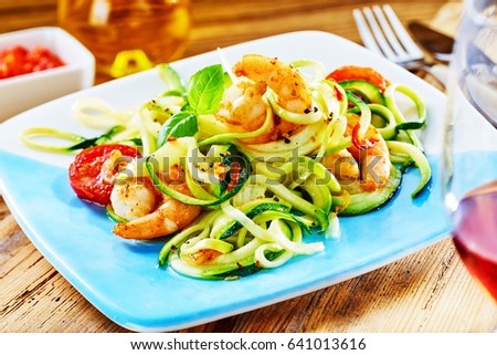 Gourmet low carbohydrate seafood appetizer with spicy grilled prawn tails in a fresh raw vegetable salad served with wine Royalty-Free Stock Photo #641013616