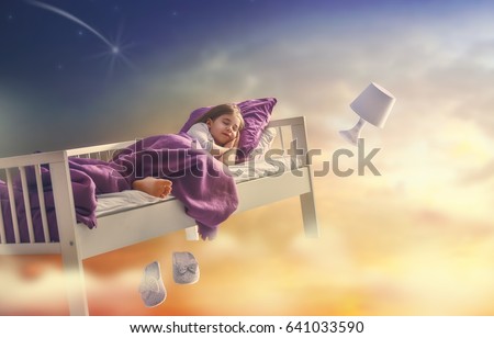 Kids dreams. Cute child girl is flying in her bed trough star sky. Royalty-Free Stock Photo #641033590