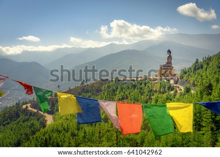 Paro Buddha with prayer flags in foreground and the valley in the background Royalty-Free Stock Photo #641042962